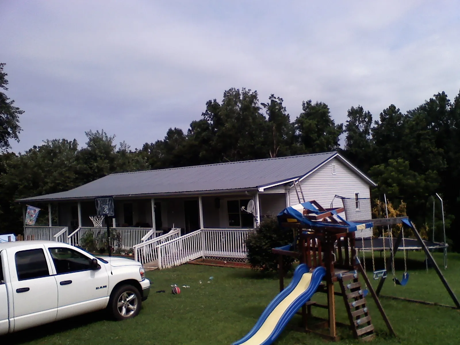 Dark metal roof on a country home with a full length front porch in Ryderwood